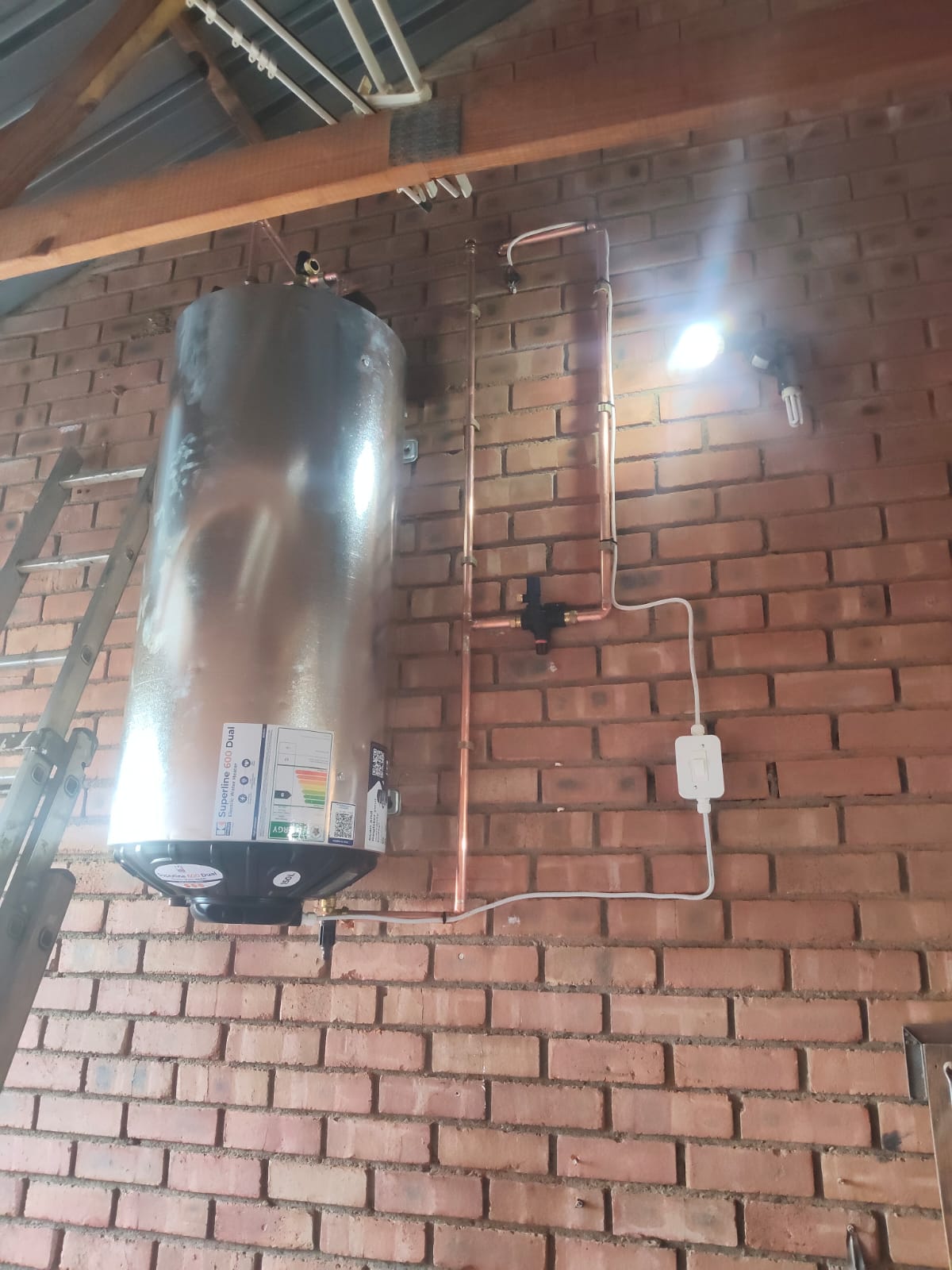 New geyser installed on a brick wall with copper pipework